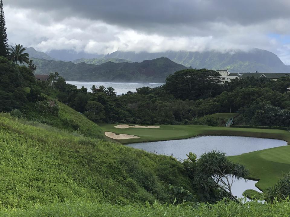 In this Nov. 16, 2018 photo, the third hole at the Princeville Makai Club in Princeville, Hawaii drops over a lake and in front of jungle on the north shore of Kauai. The waves of Hanalei Bay can been seen and heard from the tee box of the par-3 hole. (AP Photo/John Marshall)