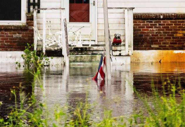 An American flag lies partially submerged in the flooded front yard of a house in New Smyrna Beach on Sept. 30. (Photo: JIM WATSON via Getty Images)