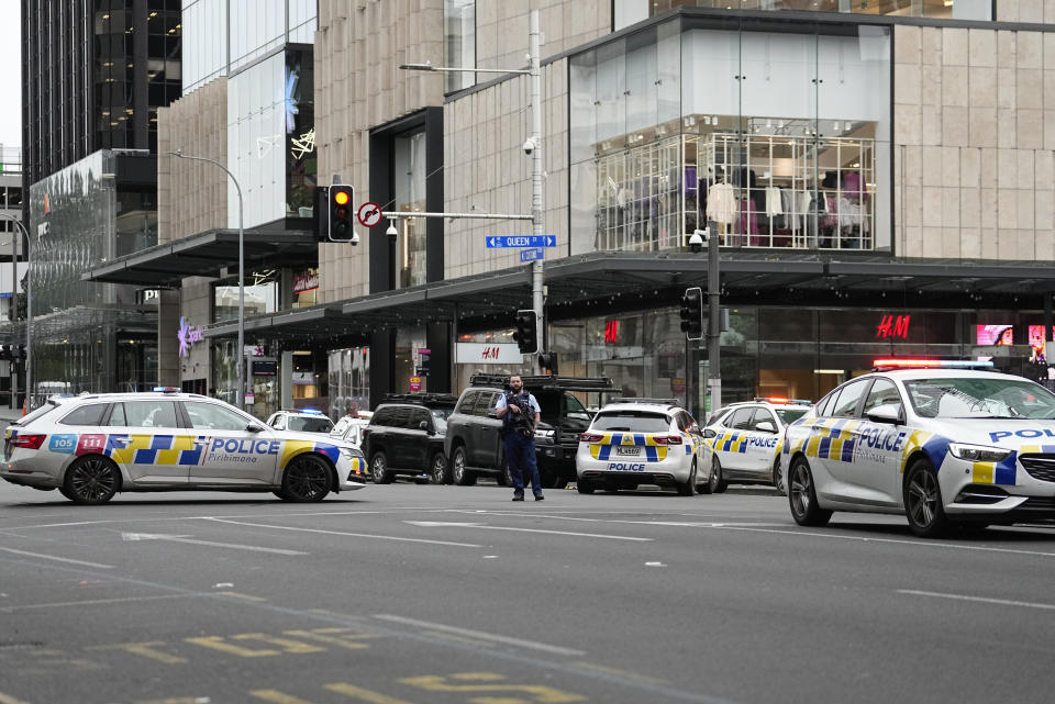 An armed New Zealand police officer stands at a road block in the central business district following a shooting in Auckland, New Zealand, Thursday, July 20, 2023. New Zealand police are responding to reports that a gunman has fired shots in a building in downtown Auckland. (AP Photo/Abbie Parr)