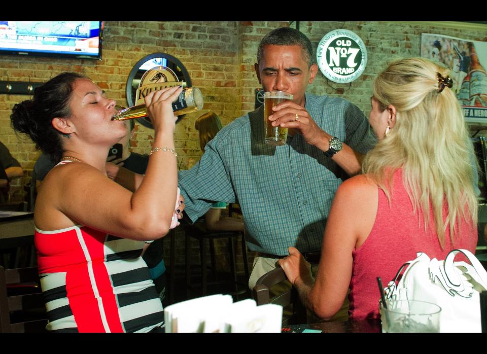 Obama shares a beer with Suzanne Woods (R) and Jennifer Klanac (L) during at Ziggy's Pub and Restaurant Amherst, Ohio, July 5, 2012, during an unannounced visit while on a bus tour of Ohio and Pennslyvania. AFP PHOTO/Jim Watson