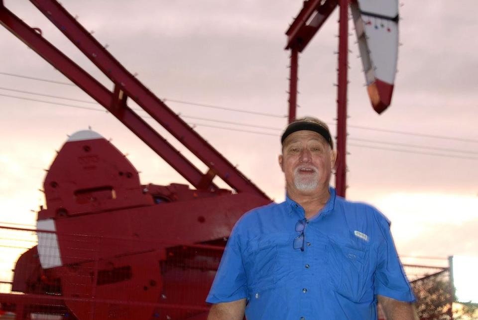 Luther Rains poses with the towering oil pumping unit at the Rudolph the Red Nosed Pumping Unit lighting ceremony in downtown Lufkin, TX, Friday, December 1, 2023.