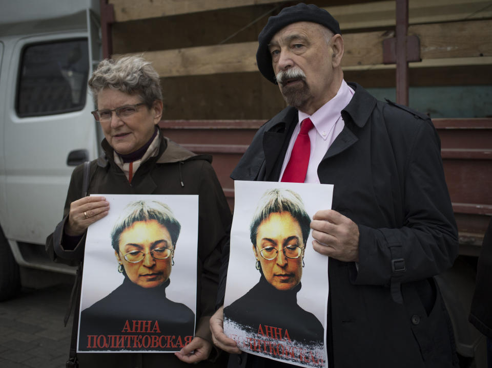 Svetlana Gannushkina, left, a mathematician and human rights activist and Valery Borshchev, a member of the Board of the All-Russian human rights movement "For Human Rights" stand holding portraits of slain journalist Anna Politkovskaya, in downtown Moscow, Sunday, Oct. 7, 2012. About 200 people rallied Thursday on the 6th anniversary of the killing of Anna Politkovskaya, calling on the authorities to find and punish the killers of journalists and human rights activists in Russia. (AP Photo/Alexander Zemlianichenko)