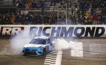 Martin Truex Jr. (19) does a burnout after winning the NASCAR Cup Series auto race at Richmond Raceway in Richmond, Va., Saturday, April 13, 2019. (AP Photo/Steve Helber)