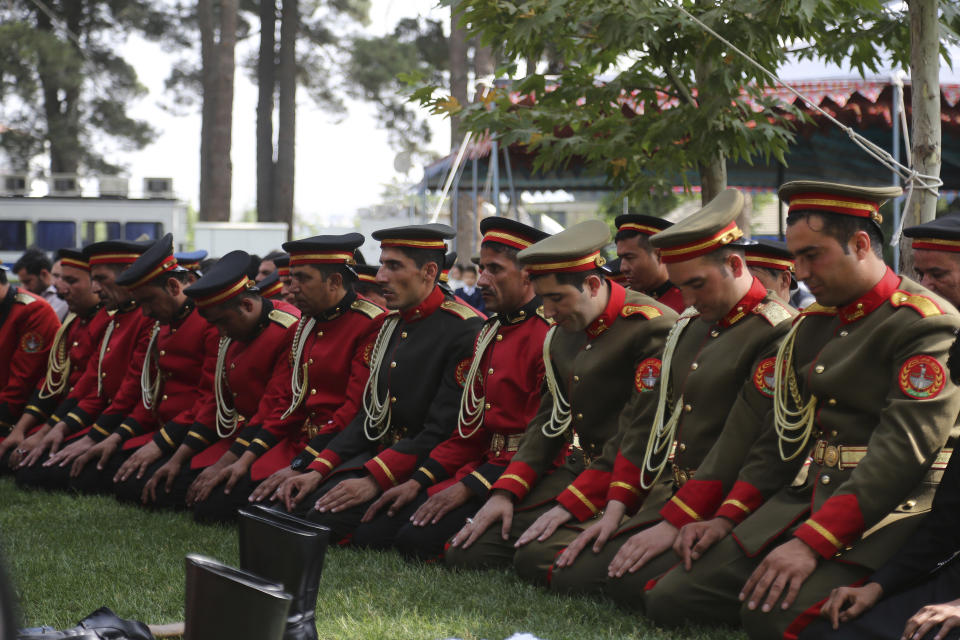 Afghan honor guards offer Eid al-Adha prayers at the presidential palace in Kabul, Afghanistan, Sunday, Aug. 11, 2019. Afghanistan's President Ashraf Ghani is urging the nation to determine its fate without foreign interference as the United States and the Taliban appear to near a peace deal without the Afghan government at the table.(AP Photo/Nishanuddin Khan)