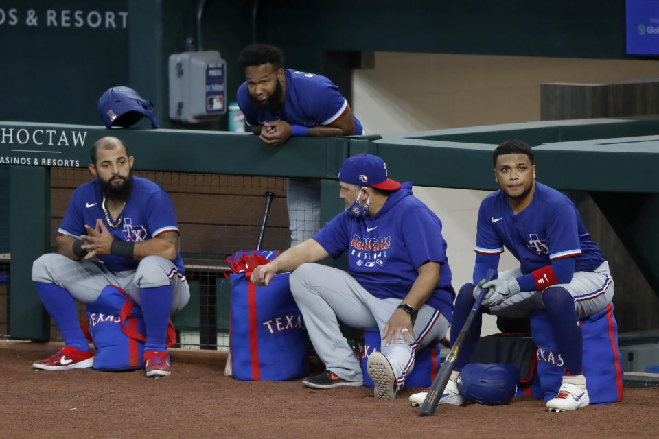 Texas Rangers' Rougned Odor, left, Danny Santana, top, catching coach Hector Ortiz and Willie Calhoun, right, participate in an intrasquad game during baseball practice at Globe Life Field in Arlington, Texas, Friday, July 10, 2020. (AP Photo/Tony Gutierrez)