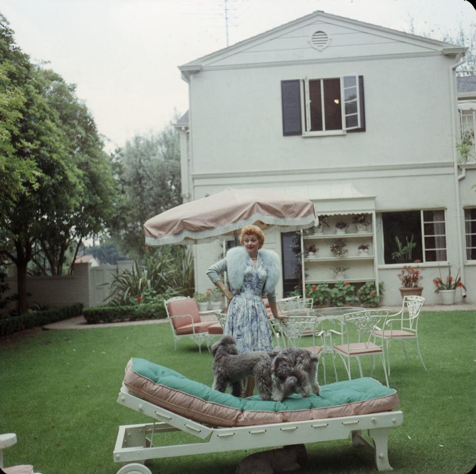 1957: Playing with her dogs in the family's backyard.