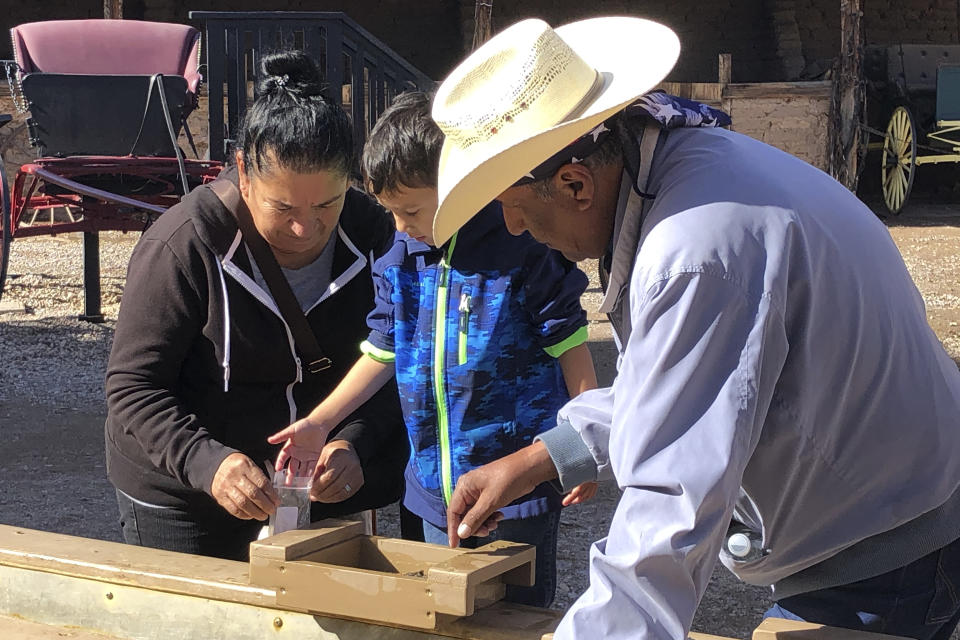 A family is seen "panning for silver" in Tombstone, Ariz., on Saturday, Nov. 30, 2019. Tombstone is famous for an 1881 gun battle that left three dead, a confrontation that has been the inspiration for numerous books and movies. The town was founded and flourished in the late 19th century after large amounts of silver were found in the area. (AP Photo/Peter Prengaman)