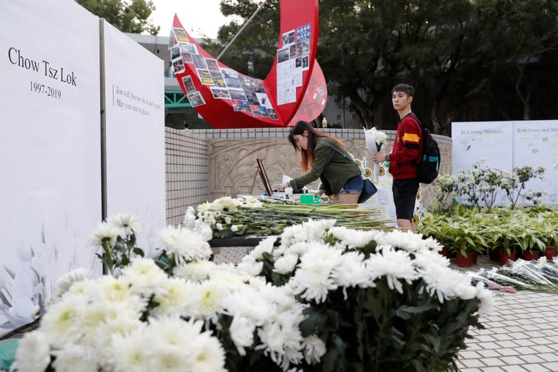 Students pay tribute with flowers to Chow Tsz-lok, 22, a university student who fell during protests at the weekend and died early on Friday morning, at the Hong Kong University of Science and Technology, in Hong Kong