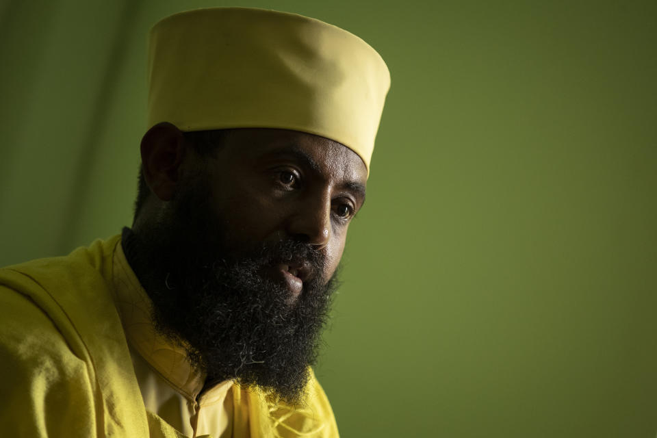 Ethiopian Orthodox Church priest Aba Yosief Desta, who hopes young people will shun ethnic-driven politics which he calls "the source of all problems", speaks to The Associated Press at his office in Gondar, in the Amhara region of Ethiopia Sunday, May 2, 2021. Ethiopia faces a growing crisis of ethnic nationalism that some fear could tear Africa's second most populous country apart, six months after the government launched a military operation in the Tigray region to capture its fugitive leaders. (AP Photo/Ben Curtis)