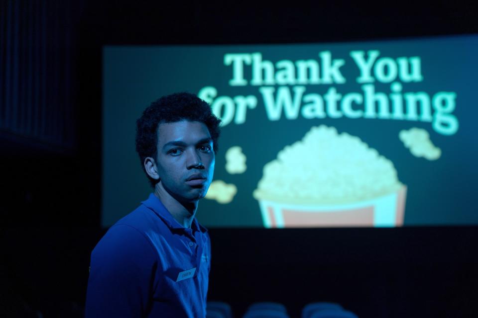 A young man in a blue shirt stands in front of a movie screen that says "Thank You for Watching" with an image of popcorn