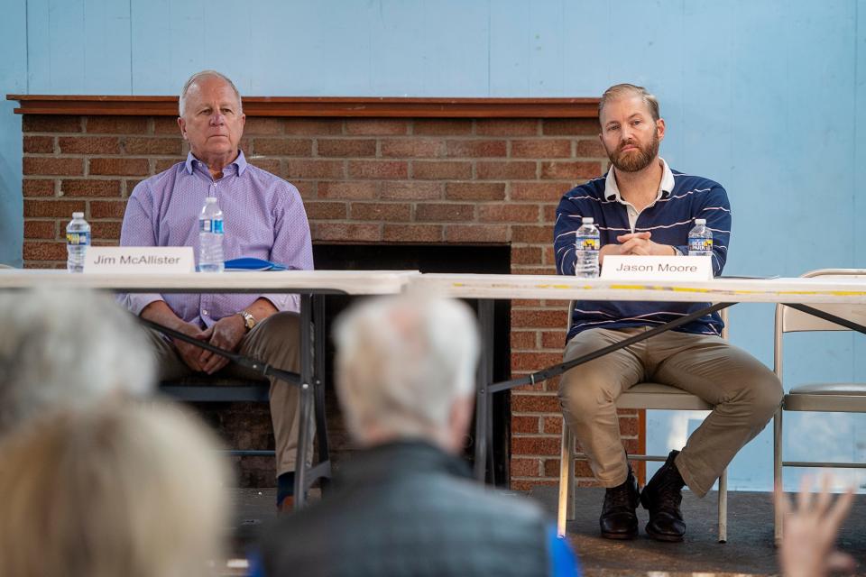 Jim McAllister, left, and Jason Moore, listen to a question from a Woodfin resident during a mayoral debate, October 26, 2023.
