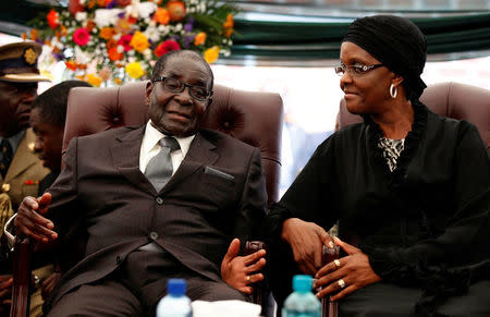 FILE PHOTO - Zimbabwe President Robert Mugabe (L) speaks to his wife Grace during the funeral of his sister, Bridget in the village of Zvimba, Zimbabwe January 21 2014. REUTERS/Philimon Bulawayo/File Photo