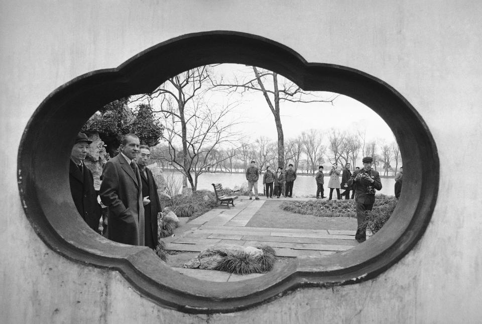 FILE - Framed in the opening of a wall, then U.S. President Richard Nixon and then Chinese Premier Zhou Enlai walks past as they tour Hangzhou in the eastern Chinese province of Zhejiang on Feb. 26, 1972. At the height of the Cold War, U.S. President Richard Nixon flew into communist China's center of power for a visit that over time would transform U.S.-China relations and China's position in the world in ways that were unimaginable at the time. (AP Photo, File)