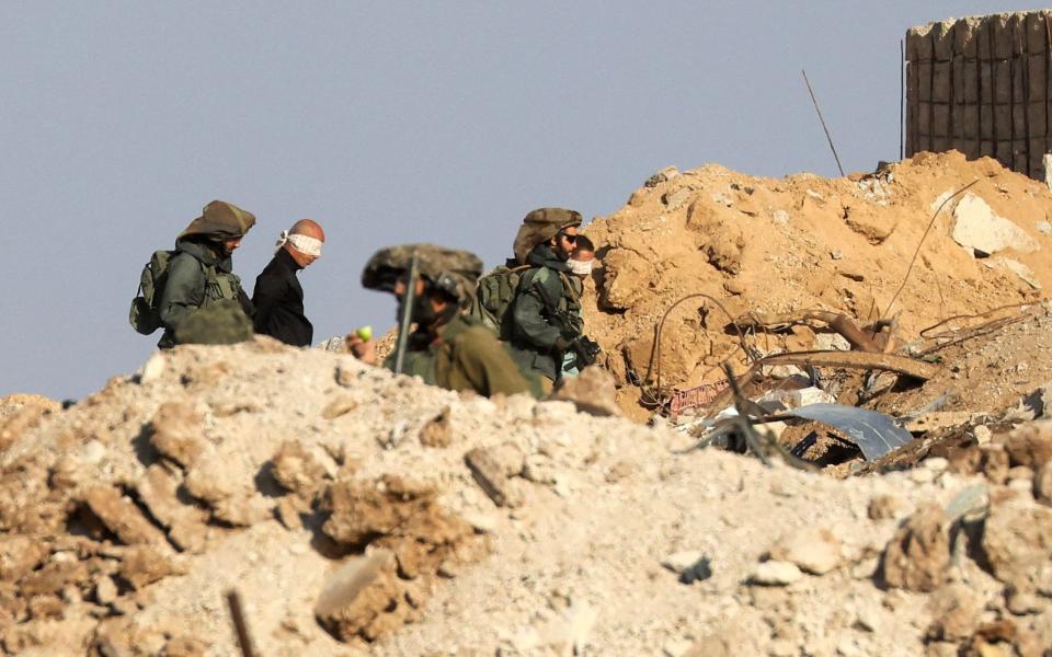 Israeli soldiers blindfold Palestinian men in the Zeitoun district on the Gaza Strip