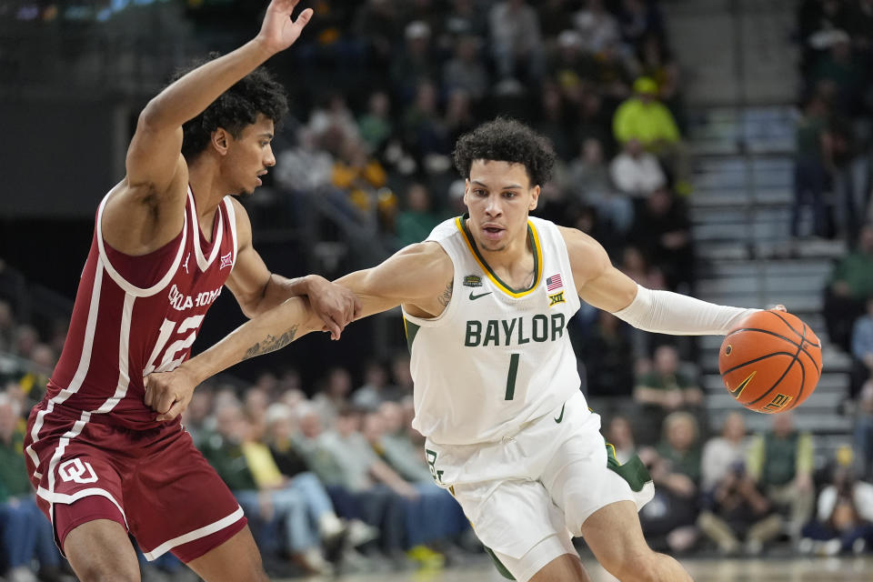 Baylor guard Miro Little (1) drives against Oklahoma guard Milos Uzan (12) during the first half of an NCAA college basketball game Tuesday, Feb. 13, 2024, in Waco, Texas. (AP Photo/LM Otero)