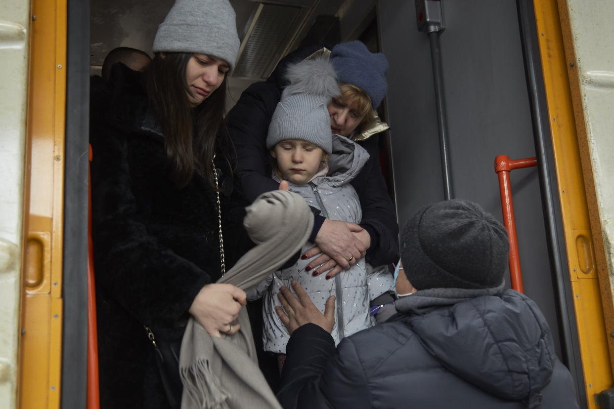 A father says goodbye to his wife and children as they board a train to evacuate Kyiv on Thursday.