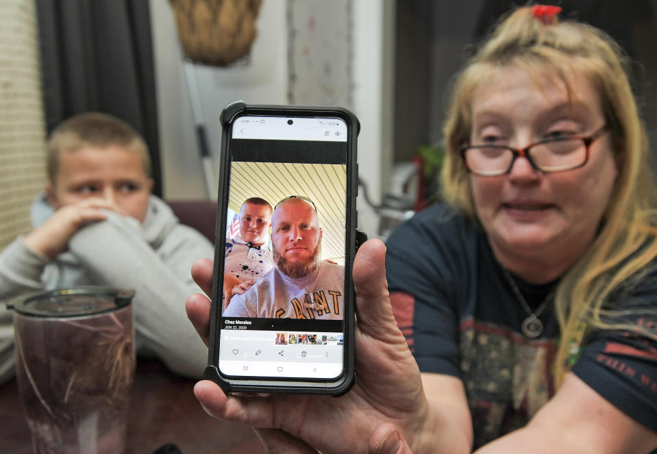 Darra Ann Morales shows a photo of her son Chaz Morales, with Chaz Jr., 10, at left, at the family home in Slidell, La., Wednesday, April 14, 2021. Darra Ann Morales is the mother and Chaz Jr. is the son of Chaz Morales, who is one of the crew members missing from the capsized vessel Seacor Power that departed from Port Fourchon when severe weather struck Tuesday. (Max Becherer/The Times-Picayune/The New Orleans Advocate via AP)