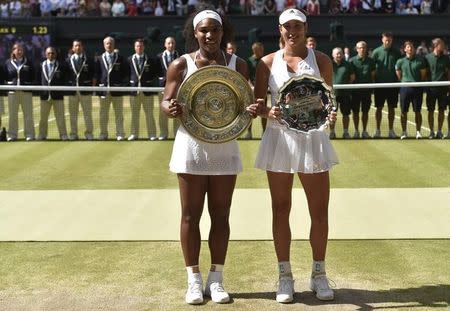 Winner Serena Williams of the U.S.A and runner up Garbine Muguruza of Spain show off their trophies after their Women's Final Match at the Wimbledon Tennis Championships in London, July 11, 2015. REUTERS/Toby Melville