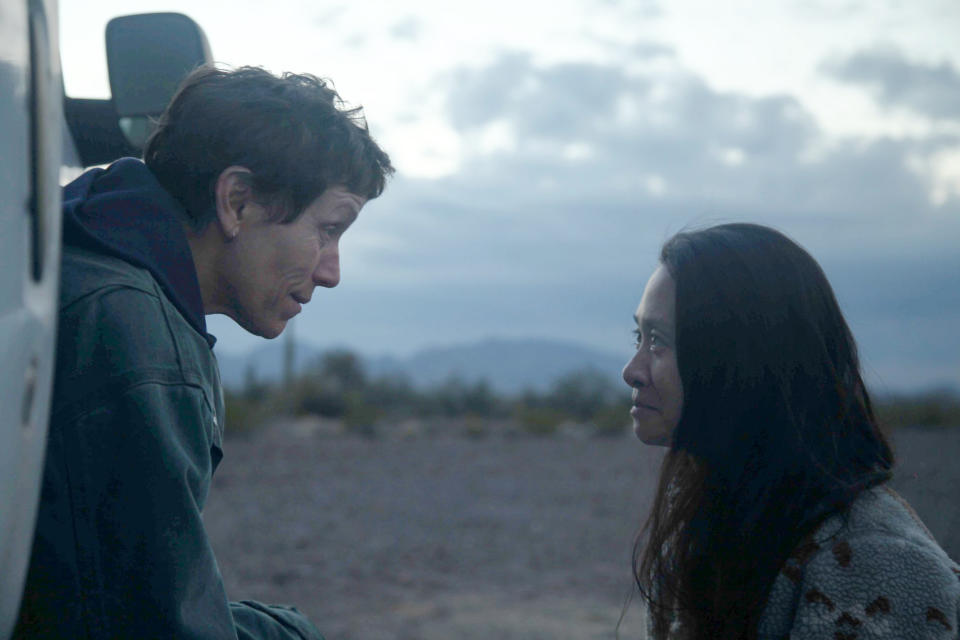 This image released by Searchlight Pictures shows Frances McDormand, left, and director Chloe Zhao on the set of "Nomadland." Zhao has made cinema of rugged authenticity, relying frequently on non-professional actors and moments of serendipity while filming. She is nominated for a Golden Globe for best director. (Searchlight Pictures via AP)