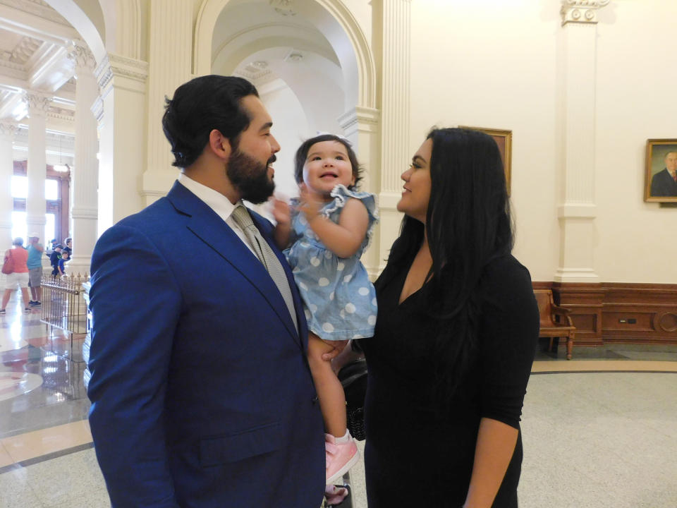 Donovon Rodriguez, chief of staff for Texas state Rep. Ray Lopez, poses for a photo at the Texas Capitol with his wife, Jenny Tavarez, and daughter, Evelyn Belle Rodriguez, for whom he is the sole provider, Monday, July 26, 2021, in Austin, Texas. Rodriguez could lose his job by Sept. 1, if legislative budget funding is not restored. (AP Photo/Acacia Coronado)