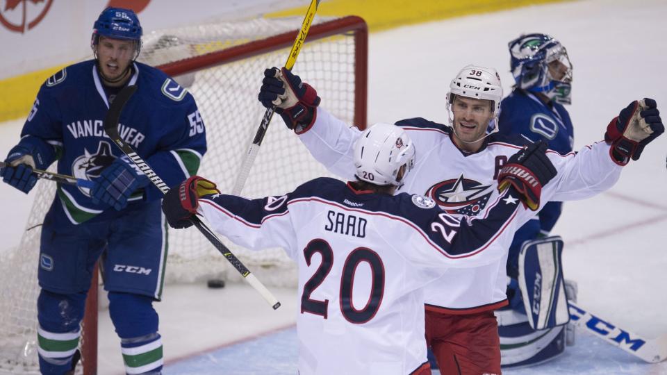 Vancouver Canucks defenseman Alex Biega (55) looks on as Columbus Blue Jackets left wing Brandon Saad (20) celebrates his goal past Vancouver Canucks goalie Ryan Miller (30) with teammate Columbus Blue Jackets center Boone Jenner (38) during the second period of an NHL hockey game, Sunday, Dec. 18, 2016 in Vancouver, British Columbia. (Jonathan Hayward/The Canadian Press via AP)