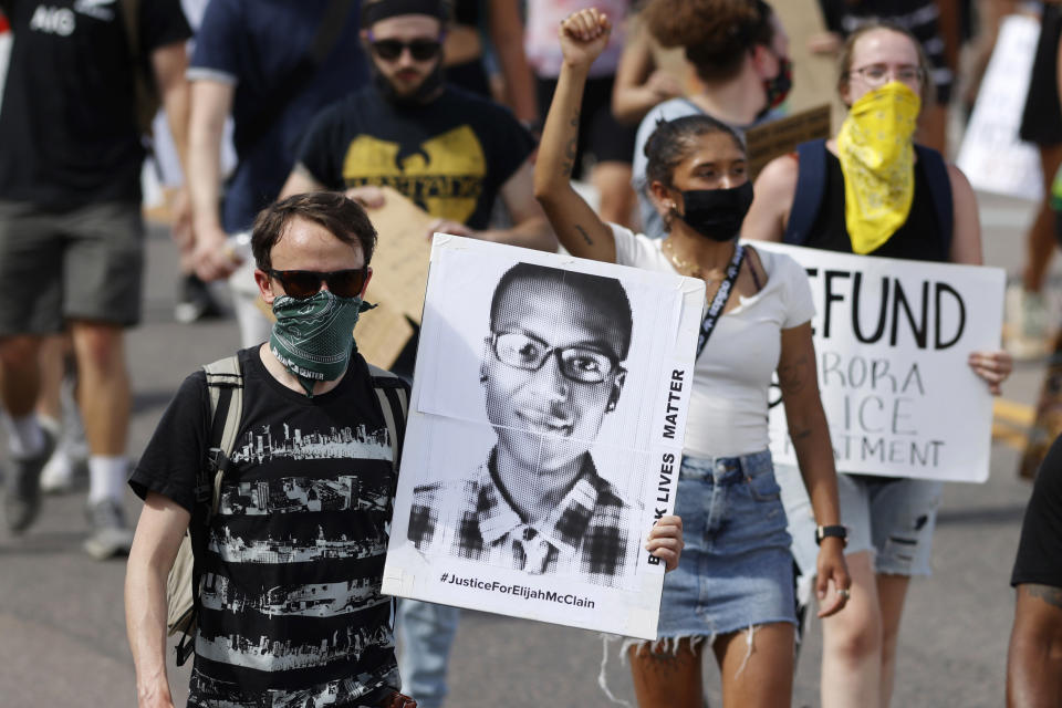 FILE - A demonstrator carries an image of Elijah McClain during a rally and march, June 27, 2020, in Aurora, Colo. Lawyers are to deliver closing arguments Tuesday, Oct. 10, 2023, in the trial of the first two police officers to be prosecuted in the 2019 death of McClain, a Black man who was put in a neck hold and pinned down by officers in the Denver suburb of Aurora before paramedics injected him with a powerful sedative. (AP Photo/David Zalubowski, File)