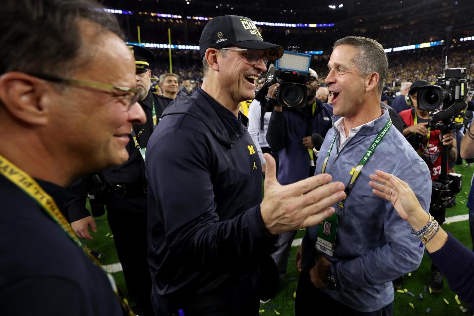 Former Michigan coach Jim Harbaugh celebrates with his brother, Ravens coach John Harbaugh during the 2024 CFP National Championship game January 8, 2024 in Houston.