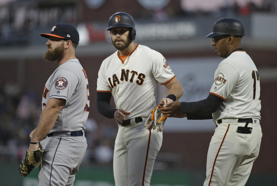 San Francisco Giants' Evan Longoria stands at first base with coach Jose Alguacil, right, after hitting a single off Houston Astros starting pitcher Charlie Morton in the fourth inning of a baseball game Monday, Aug. 6, 2018, in San Francisco. At left is Houston Astros first baseman Tyler White. (AP Photo/Eric Risberg)