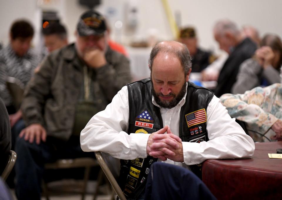 Darren Teis bows his head during an invocation at the Greater Canton Veterans Service Council's Veterans Day ceremony at American Legion Post 44 in Canton, where his family member, Bradley Teis, was posthumously honored as one of two 2022 Veteran of the Year recipients.