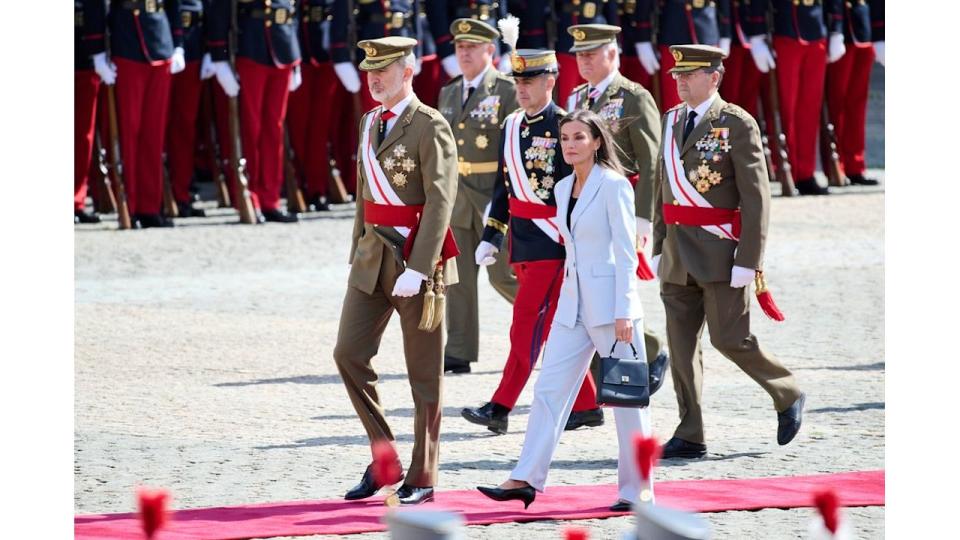 Queen Letizia in suit walking with military officers