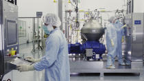 In this undated image from video provided by Regeneron Pharmaceuticals on Friday, Oct. 2, 2020, scientists work with a bioreactor at a company facility in New York state, for efforts on an experimental coronavirus antibody drug. Antibodies are proteins the body makes when an infection occurs; they attach to a virus and help the immune system eliminate it. (Regeneron via AP)