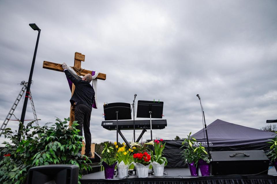 Doug Walter, student pastor at First Church of God, makes adjustments to the cross during a community drive-in Easter worship service on Sunday, April 12, 2020 in Tallmadge, Ohio.