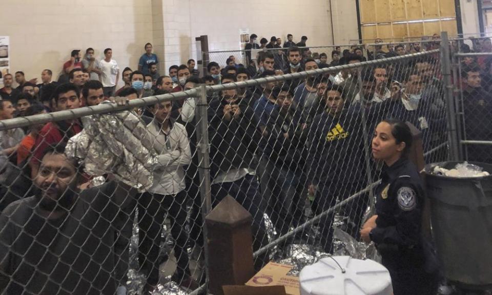 Men stand in a US border detention center in McAllen, Texas, 12 July 2019, as Mike Pence visited.