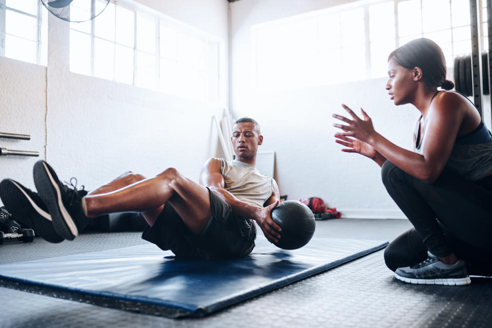 A woman coaching a man through his workout