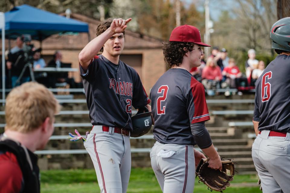 Dover's Mason Stoldt gestures to teammates after knocking a solo home run over the left field fence against New Philadelphia in the first inning Friday night.