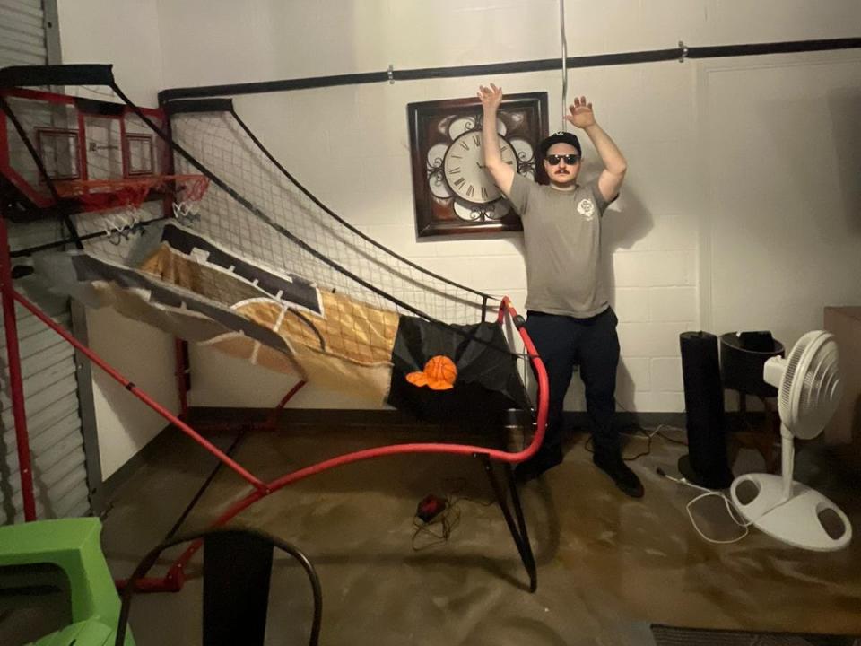 The writer poses next to a basketball net