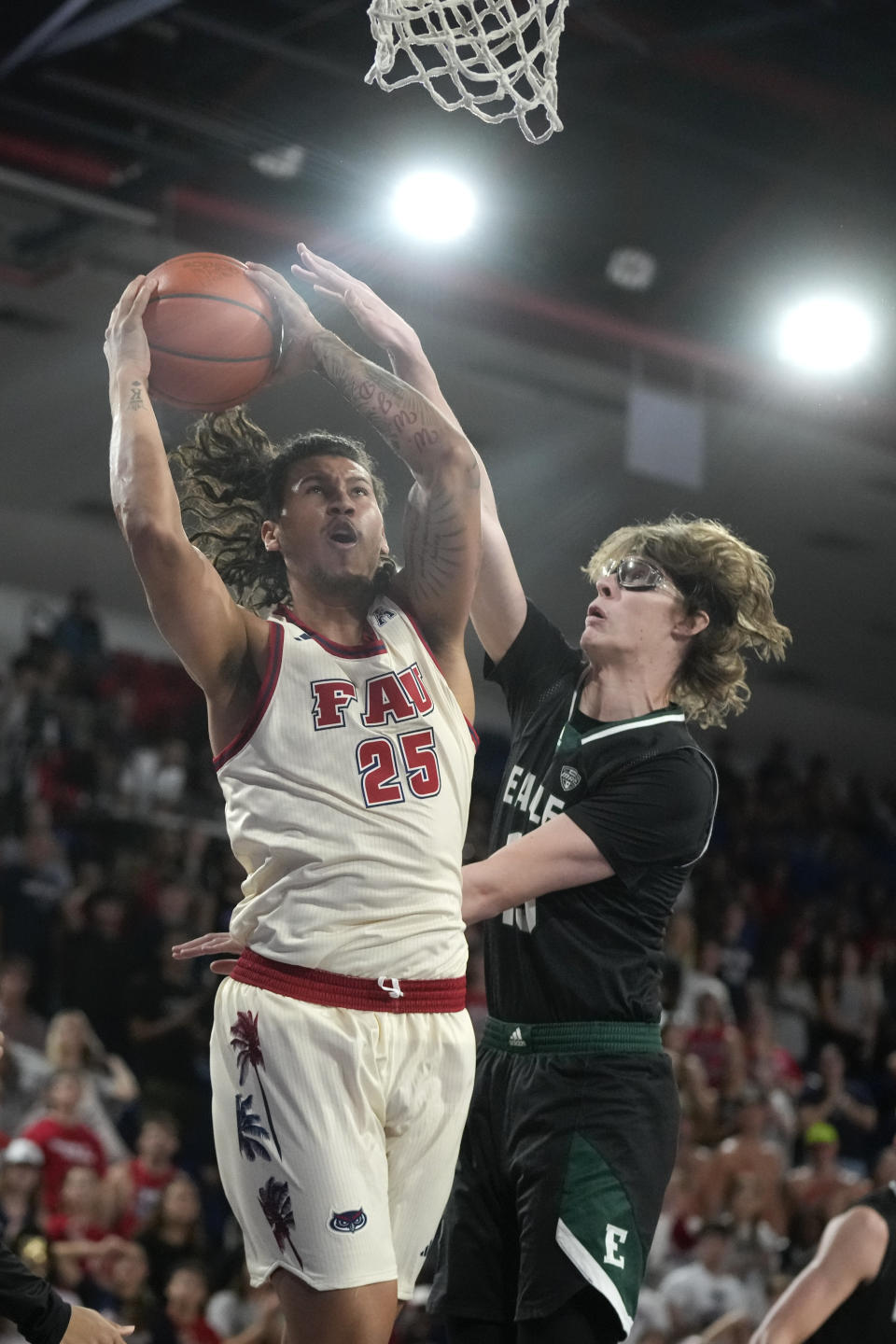 Florida Atlantic forward Tre Carroll (25) goes to the basket while defended by Eastern Michigan forward Derik Pranger (15) during the second half of an NCAA college basketball game Tuesday, Nov. 14, 2023, in Boca Raton, Fla. (AP Photo/Rebecca Blackwell)