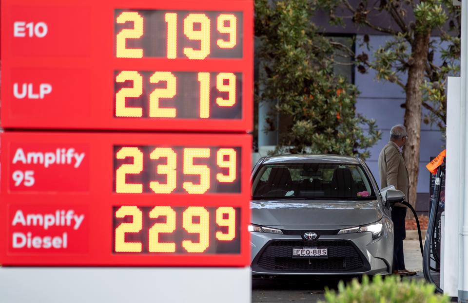 A man fills up his car at a petrol station.