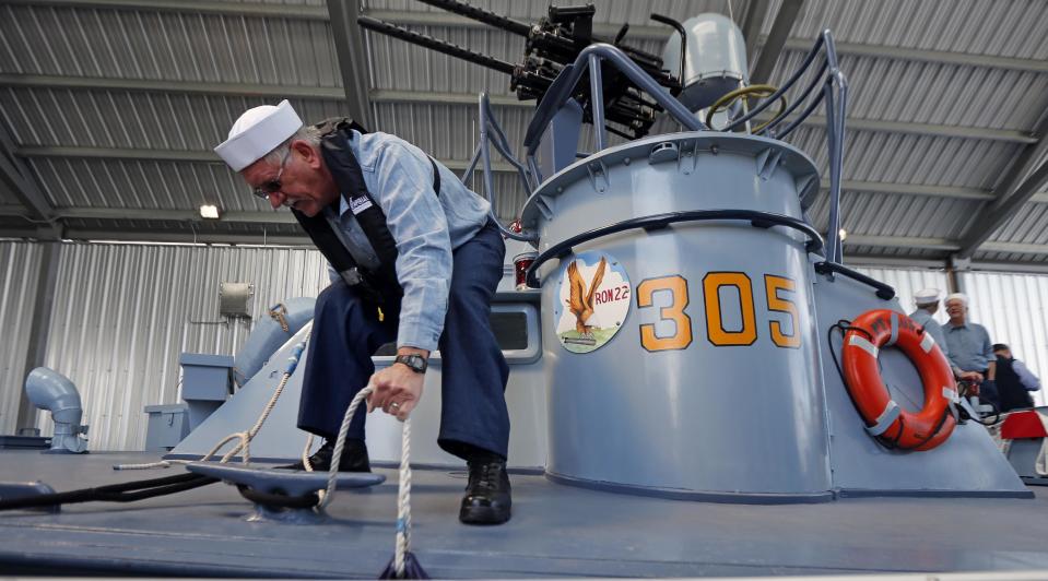 Crew member Malcolm Hartman docks the boat after a media ride of the PT 305, which was restored by the National WWII Museum, on Lake Pontchartrain, where she was originally tested by Higgins Industries more than 70 years ago, in New Orleans, Thursday, March 16, 2017. The U.S. Navy PT boat that sank three vessels and saw action in Europe in World War II is back in New Orleans where it was built, what historians describe as the nation's only fully restored combat ship of that type from the era. Its return to water is the culmination of a 10-year restoration project by the museum. (AP Photo/Gerald Herbert)