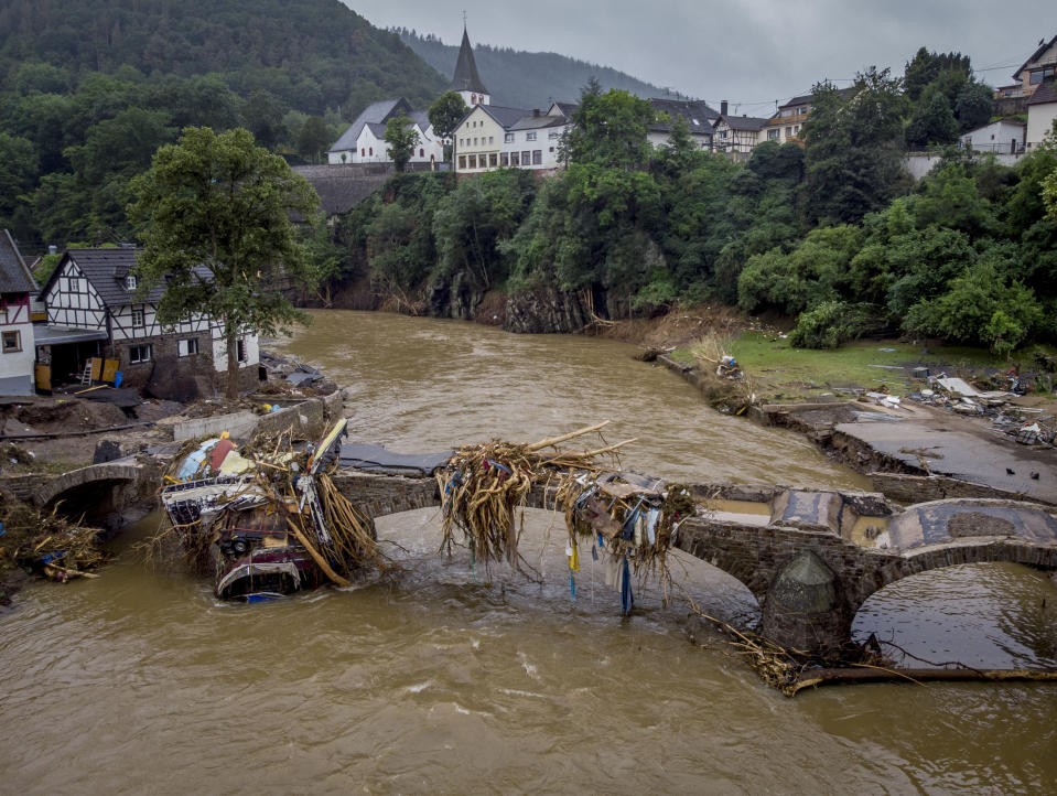 Debris hangs on a damaged bridge over the Ahr river in Schuld, Germany, Friday, July 16, 2021. Two days before the Ahr river went over the banks after strong rain falls causing severals deaths and hundreds of people missing. (AP Photo/Michael Probst)