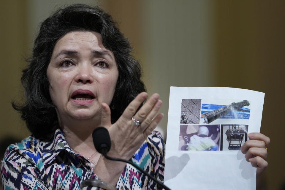 Qelbinur Sidik, a member of China's ethnic Uzbek minority who was forced to teach Chinese in separate detention facilities for Uyghur men and women, holds up images as she testifies during a special House committee hearing dedicated to countering China, Thursday, March 23, 2023, on Capitol Hill in Washington. This hearing is to focus on the Chinese government's treatment of its Uyghur population. (AP Photo/Carolyn Kaster)