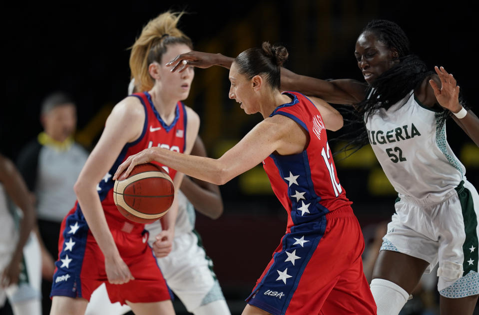 United States' Diana Taurasi (12), center, is fouled by Nigeria's Ify Ibekwe (52) during women's basketball preliminary round game at the 2020 Summer Olympics, Tuesday, July 27, 2021, in Saitama, Japan. (AP Photo/Charlie Neibergall)