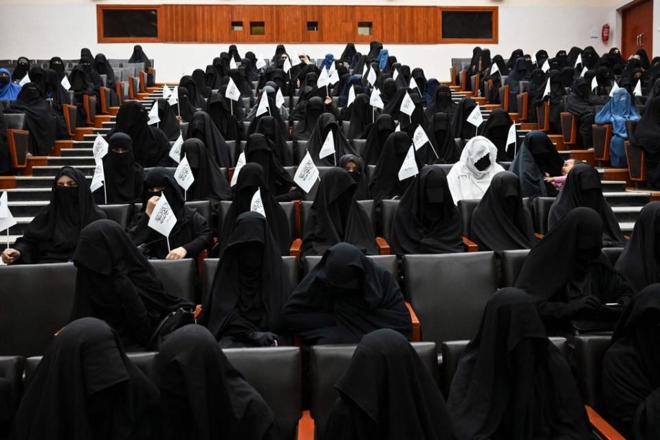 Veiled students hold Taliban flags as they listen a speaker before a pro-Taliban rally at the Shaheed Rabbani Education University in Kabul on September 11 (AFP via Getty Images)