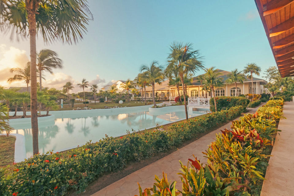 A tree-lined pool area at Sunwing's Memories Cayo Largo resort at sunset