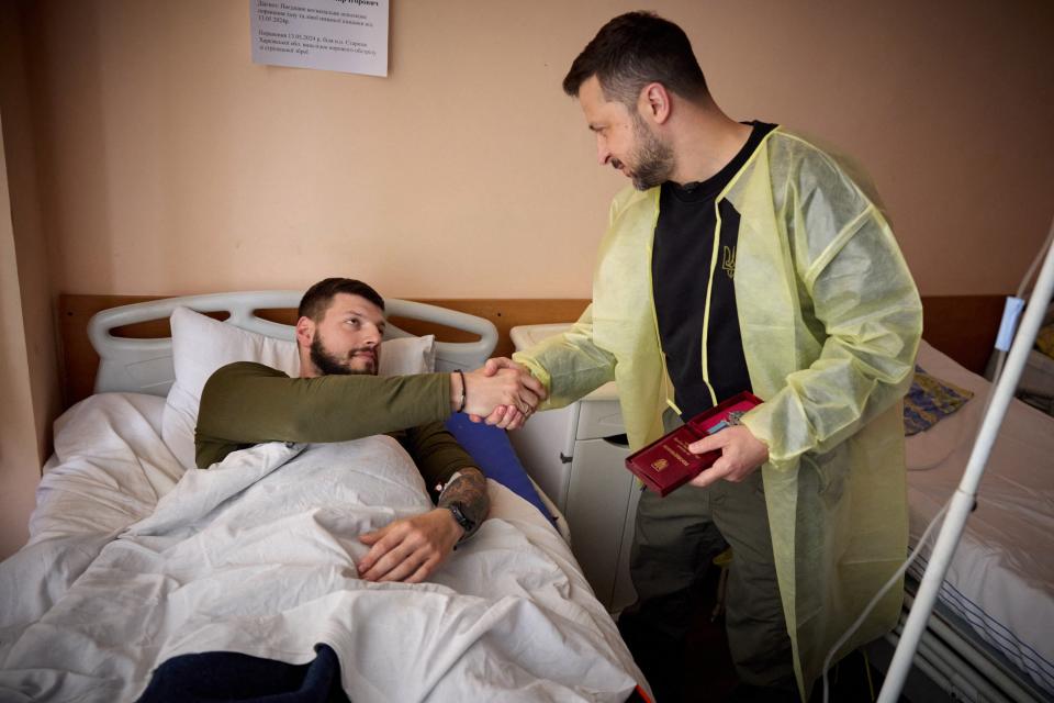 Ukraine’s President Volodymyr Zelensky (R) awards a wounded Ukrainian serviceman at a hospital in Kharkiv (UKRAINIAN PRESIDENTIAL PRESS SER)