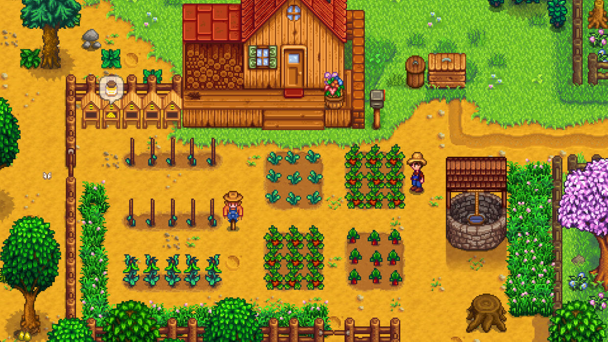  Stardew Valley screenshot - farmer standing next to a well near his field and house. 