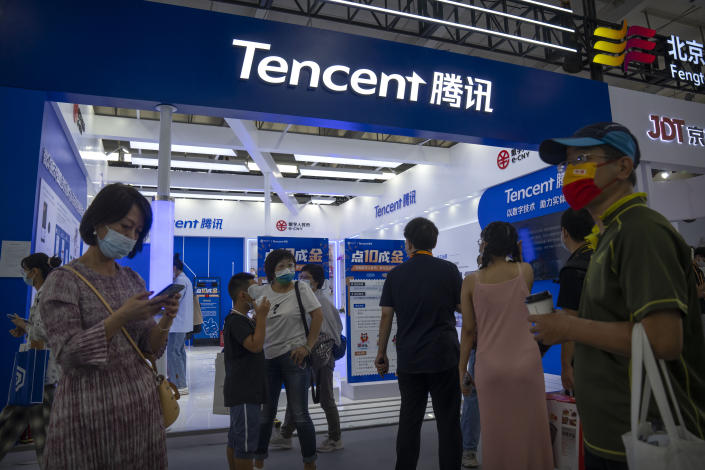 FILE - Visitors gather near a booth for Chinese technology firm Tencent at the China International Fair for Trade in Services (CIFTIS) in Beijing, on Sept. 3, 2022. A grinding crackdown that wiped billions of dollars of value off Chinese technology companies is easing, but the once-freewheeling industry is bracing for much slower growth ahead. (AP Photo/Mark Schiefelbein, File)