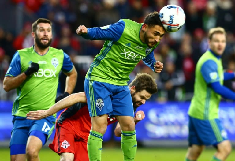 Cristian Roldan of the Seattle Sounders clears a high ball in front of Drew Moor of Toronto FC during the 2017 MLS Cup Final