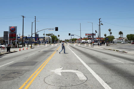 A man walks in the blocked off intersection of Florence and Normandie Avenue, the flashpoint where the riots started 25 years ago, after a march to remember and honor the victims of the 1992 Los Angeles riots in Los Angeles, California, U.S., April 29, 2017. REUTERS/Kevork Djansezian