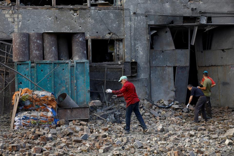 Workers remove debris at a site in an industrial area damaged during a Russian missile strike (REUTERS)